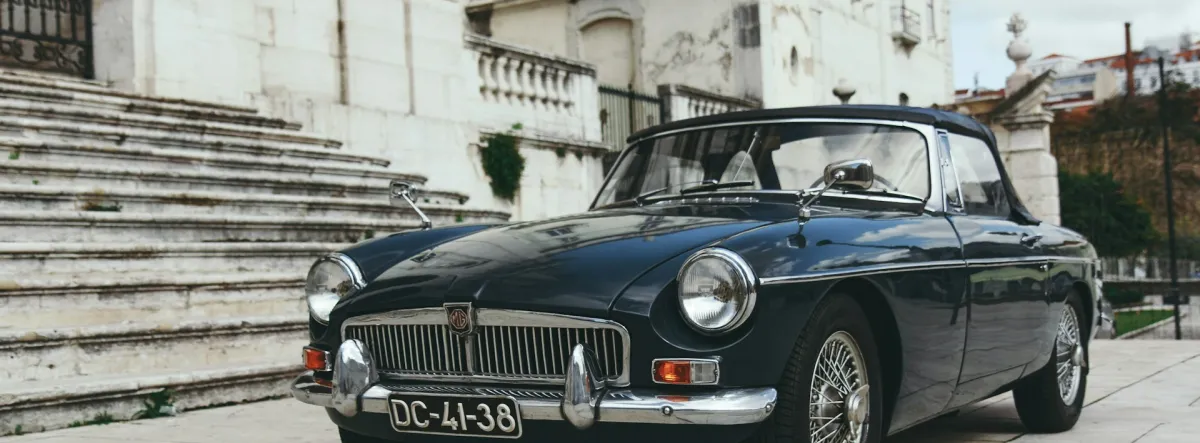 Classic car parked next to stone steps